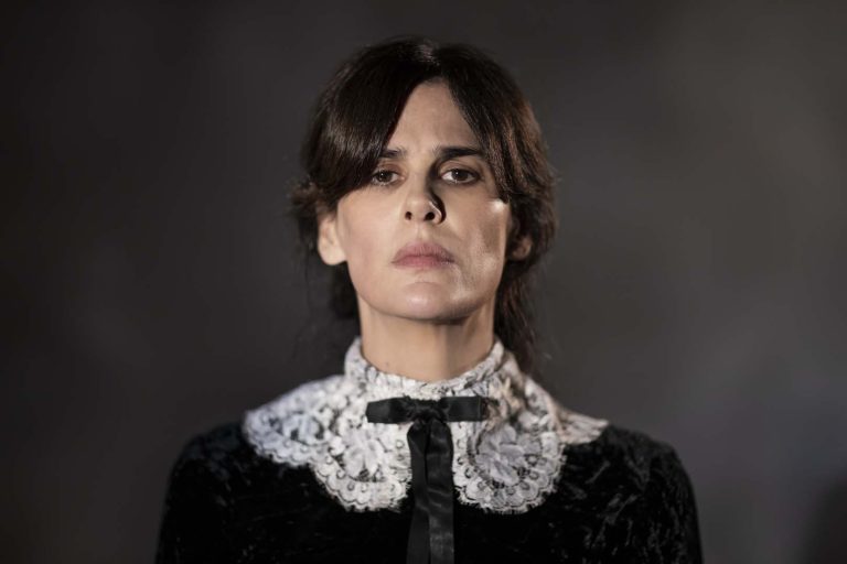 SAO PAULO, SP, BRASIL, 15-04-2023: Dayse se apresenta para os professores do Liceu, que a subestimam, ela não consegue ler sua peça.. Na São Paulo de 1919, a operária de uma gráfica ganha uma bolsa para estudar em Paris e concretizar o desejo quase impossível de tornar-se autora de teatro. Porém, engravida do amante que não quer que ela vá. Com poucos recursos financeiros, ela irá enfrentar uma secreta e violenta jornada para realizar um aborto clandestino, enquanto luta para levar adiante o sonho de imprimir sua voz em um mundo onde as mulheres sequer são donas do próprio corpo. - (Foto: Fabio Braga/Pivô Audiovisual) DIVULGAÇÃO.