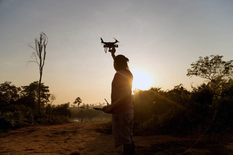 Kamikiá Kisêdjê, cineasta indígena em ação, pilotando drone durante o nascer do Sol na aldeia Khinkatxi. Várias etnias se reuniram para a festa dos 20 anos da demarcação da TI Wawi