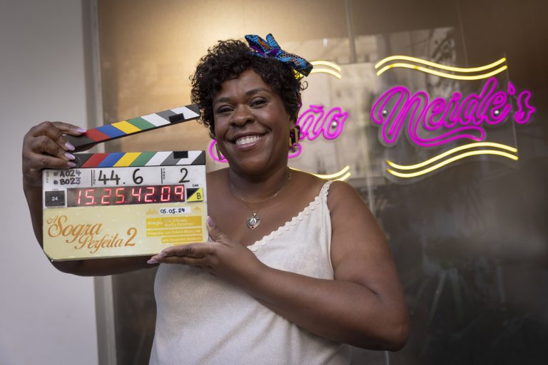 SAO PAULO, SP, BRASIL, 05-05-2024: Sheila grita para Neide. Neide aparece na janela para ver. . Depois de ter conquistado a casa para si com grande estorço, Neide está determinada a continuar morando sozinha. Quando Oliveira, seu namorado e padeiro português do bairro, a pede em casamento, ela responde firmemento: com um "não!". No entanto, Dona Oliveira, sua sogra portuguesa, chega à Vila Cleido pronta para a festa de casamento: Diante da insistencia da senhorinha, Neide se sente
pressionada e decide provar sua independência a todo custo e chega a assumir em rede nacional todo o mérito pelo sucesso do salão e da nova barber shop de Sheila, deixando a melhor amiga magoado. Neide acredita que sua independência é sua maior qualidade e decido se preparar sozinha para o concurso, Transformation, uma competição anual de salões de beleza:
No entanto, Neide passa a se sentir solitária e entende que, para conseguir sua melhor amiga e seu namorado de volta, terá que aprender que nada se conquista sem apoio. Com esse aprendizado, ela também entende que, apesar de ser casca grosso, deseja se casar com Oliveira. (Foto: Fabio Braga/Pivô Audiovisual, Cris D'Amato)DIVULGAÇÃO.